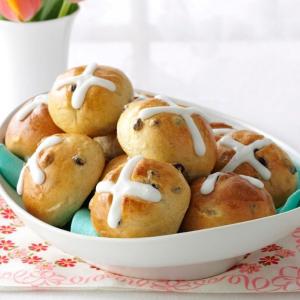 A basket of hot cross buns, neatly crossed with frosting.