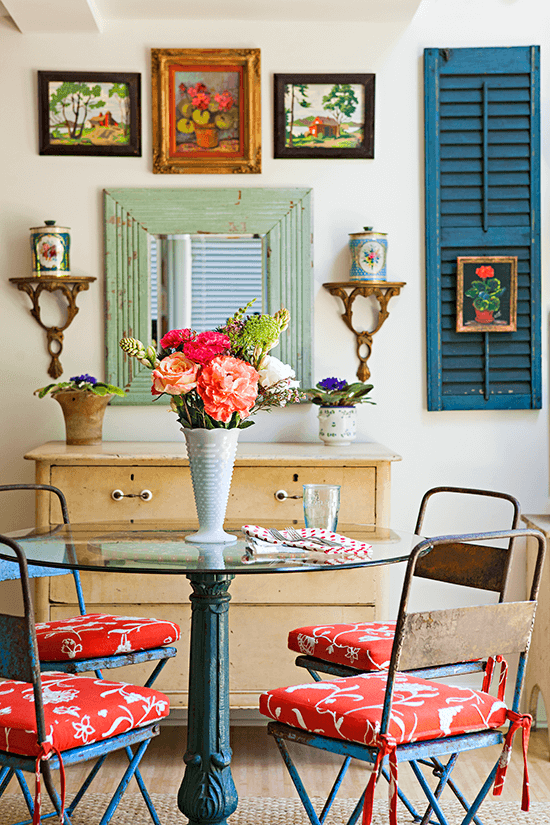 vintage patio set used inside as a dining table. flea market art hangs on the walls