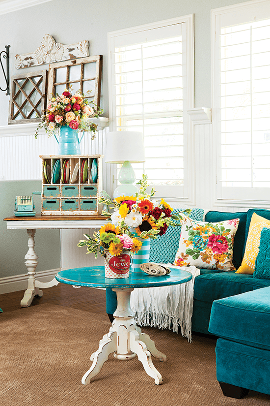 Vibrant teal microsuede sectional with a pedastal coffee table to match. Vintage and thrifted treasures in the background. 