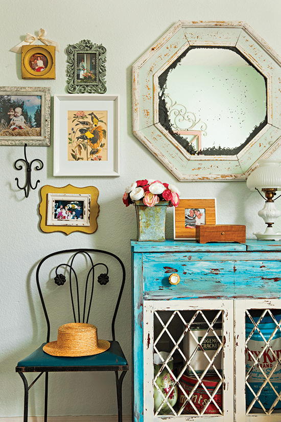 colorful vintage cottage corner with a yard sale find dresser, given a new life and placed as a focal point under a statement mirror and framed family photos on the wall. 