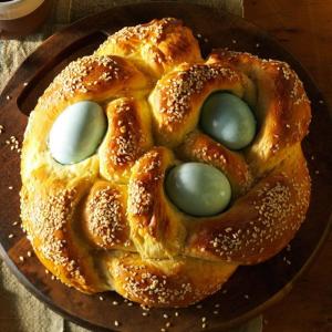 A loaf of bread with dyed easter eggs braided into it.