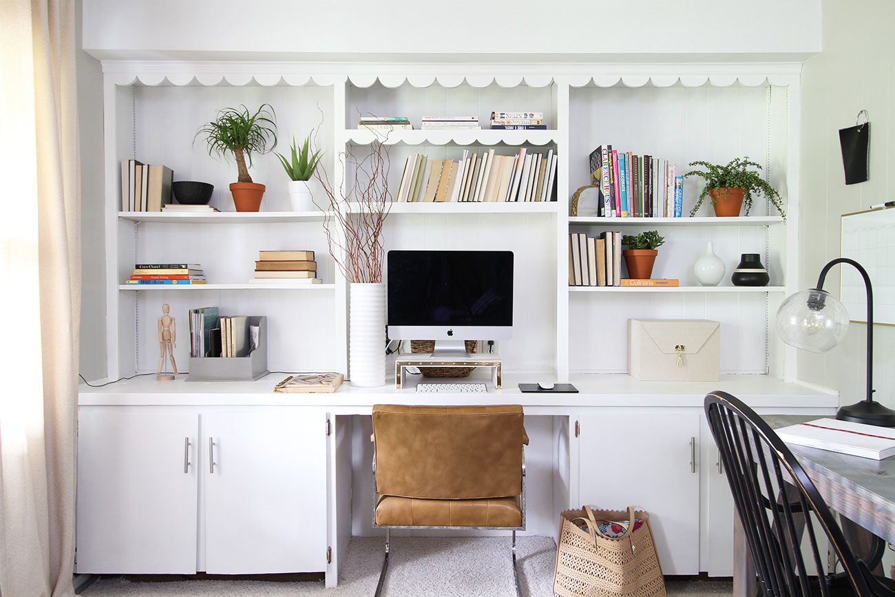 A white office with open shelves that are neatly organized.