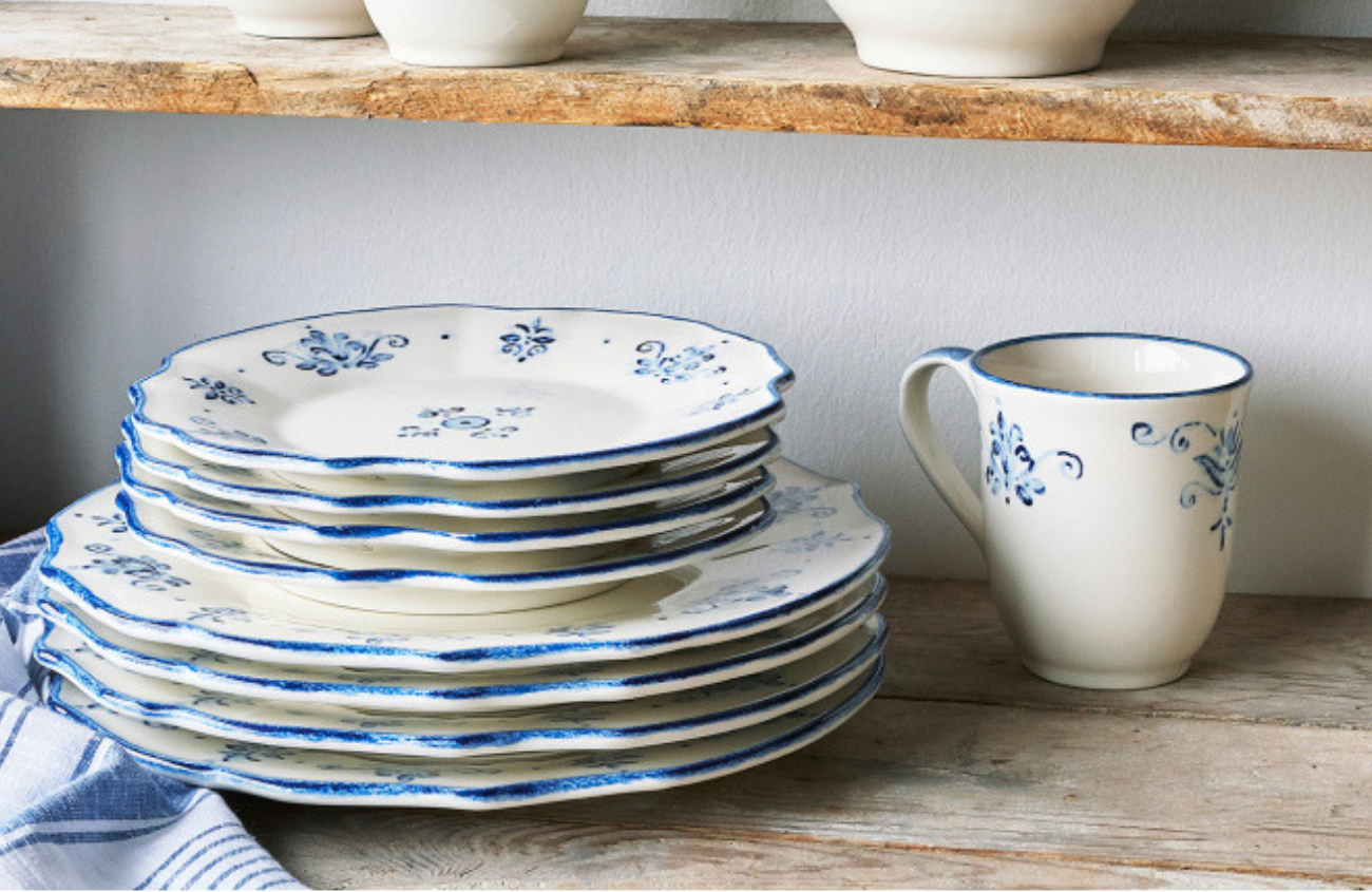 White dishes with cobalt blue floral accents laid out on rustic wood