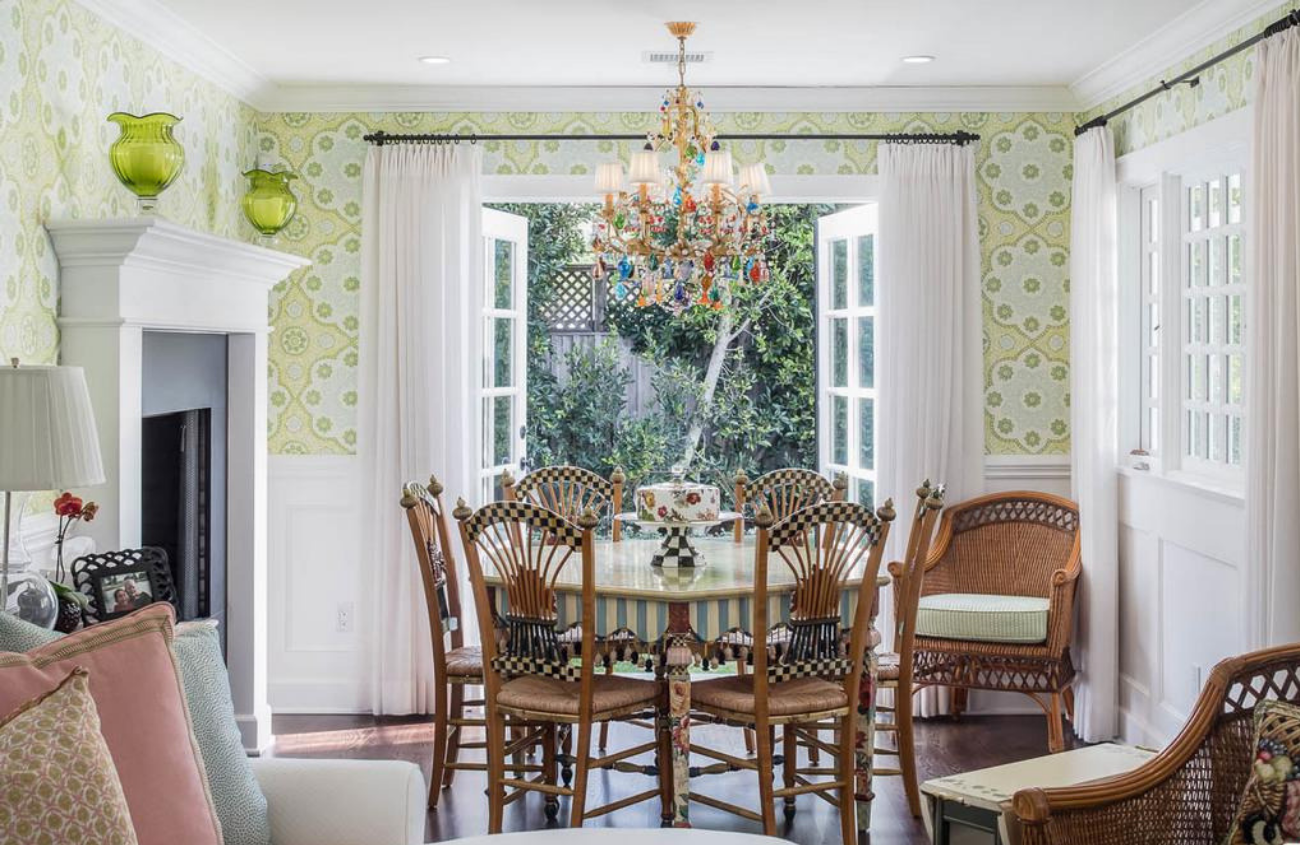 Cottage style dining room with table and chairs and French doors open to the backyard.