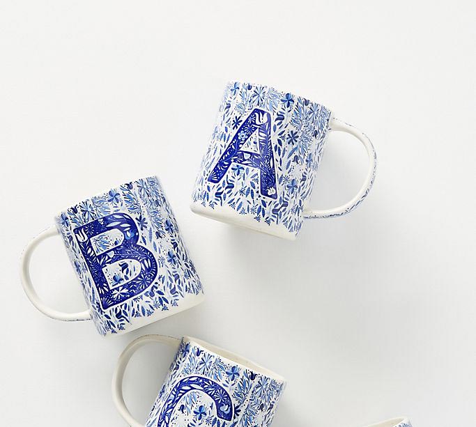 A folk song mug with blue painterly flowers and letters from anthropologie