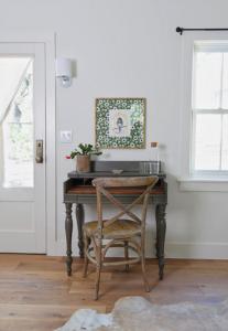 Writing desk with custom wall art and bright and airy windows and doors.