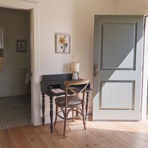 Open door letting in sunlight on a charming writing desk.