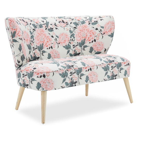 Light colored floral upholstered bench with light wooden legs.