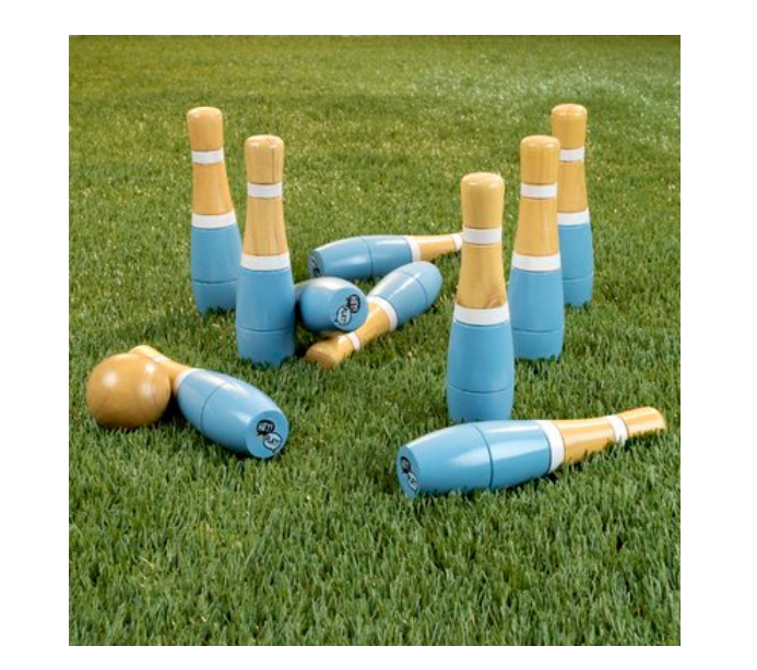 Green grass and wooden and turquoise lawn bowling pins and ball