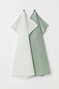 Two tea towels, one green, one white with a green grid pattern.