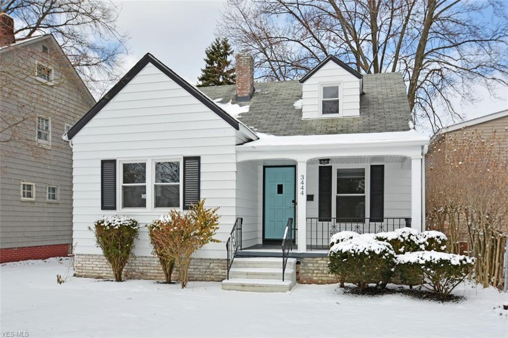 white shiplap cottage with turquoise door