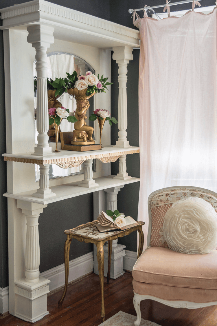 white fireplace surround with gold accent side table and a Craigslist antique pink and white seat.