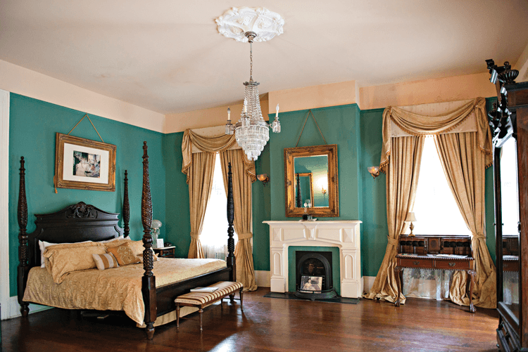 antique four-poster bed and crystal chandelier in a bedroom at Degas House