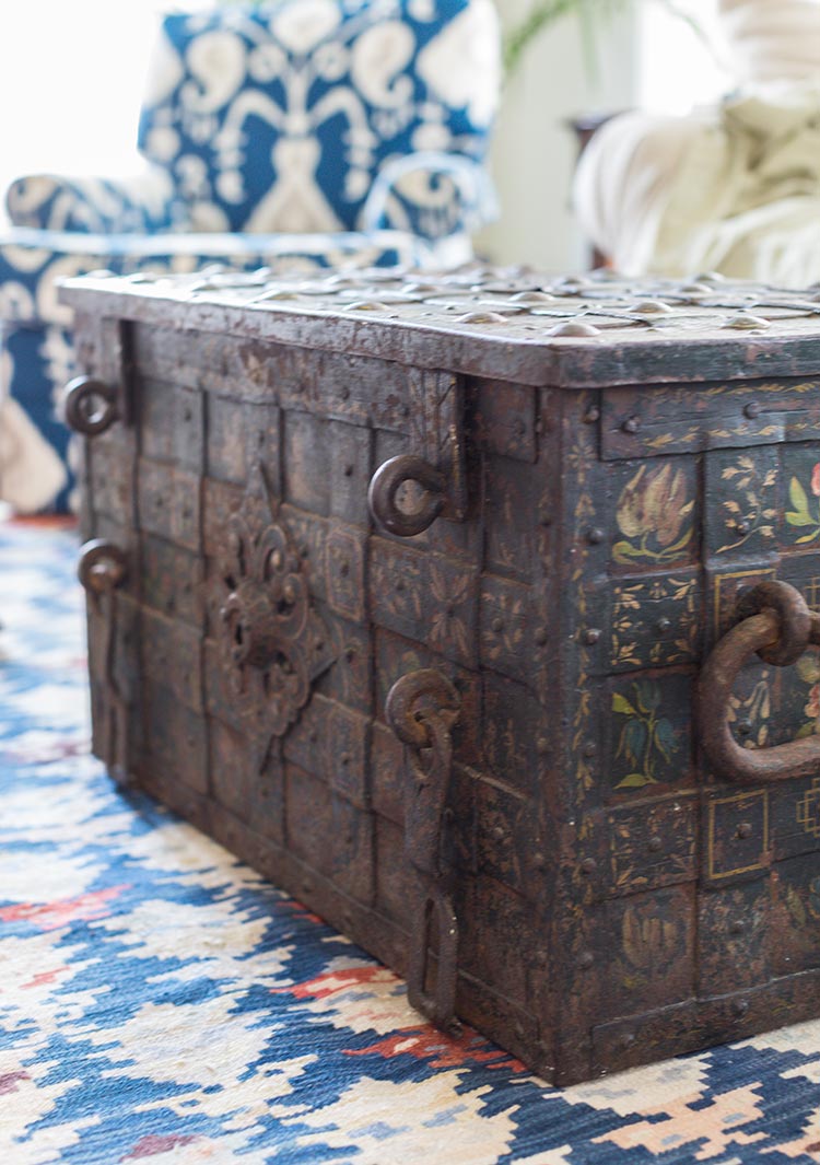 A folk-painted trunk coffee table on a blue rug