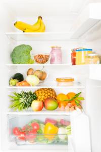 Fridge shelves filled with fruits and vegetables.