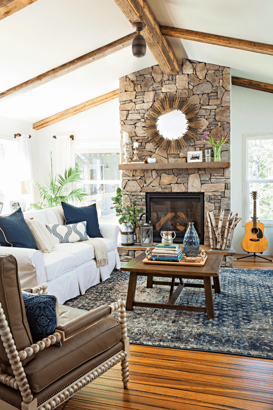 A full vertical view of the room addition's pitched ceiling with exposed beams and dramatic stone fireplace.