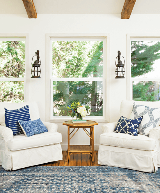 White room with blue accents, this room addition has gorgeous ceiling beams as well as a freshly updated rug and fresh throw pillows to compliment the beautiful white furniture.