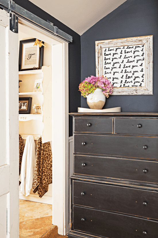 black shabby painted dresser with word art hanging above