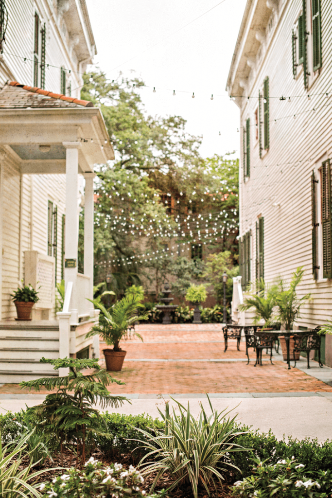 a brick patio with fairy lights and side porch