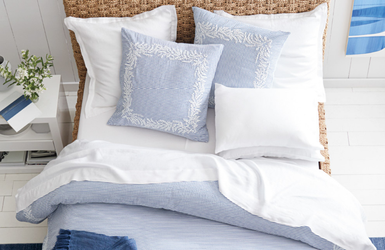 Light blue and white detailed duvet cover set featured on a bed.
