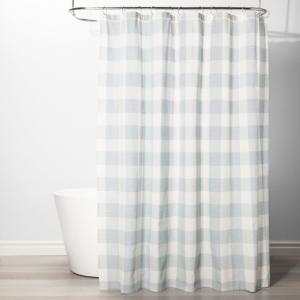 white bath tub featuring light blue and white gingham shower curtain.