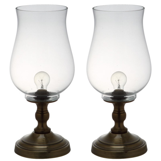 Two hurricane lamps for a bedside table, bronze bottoms and glass hurricane shaped tops. 