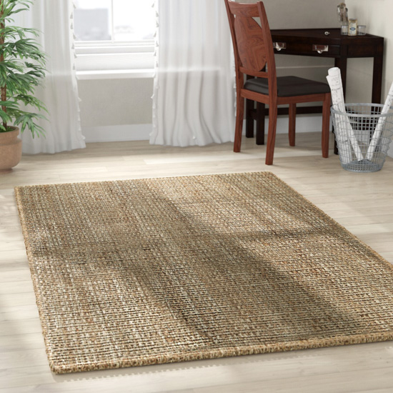 Handwoven natural colored area rug laid out on floor.