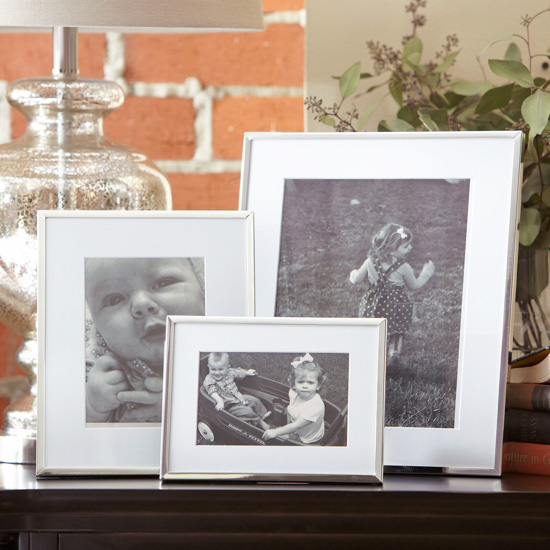 Set of 3 displayed picture frames with white matting and silver edge. 