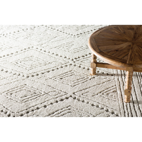 Cream colored floor area rug and wooden coffee table. 