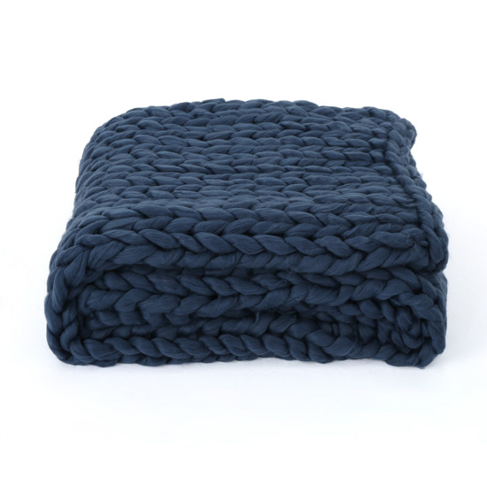 Chunky knit navy blue throw blanket, folded neatly. 