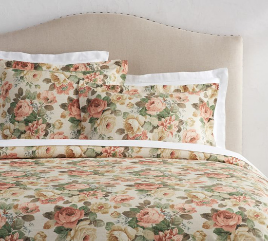 Beige upholstered headboard and floral duvet set .