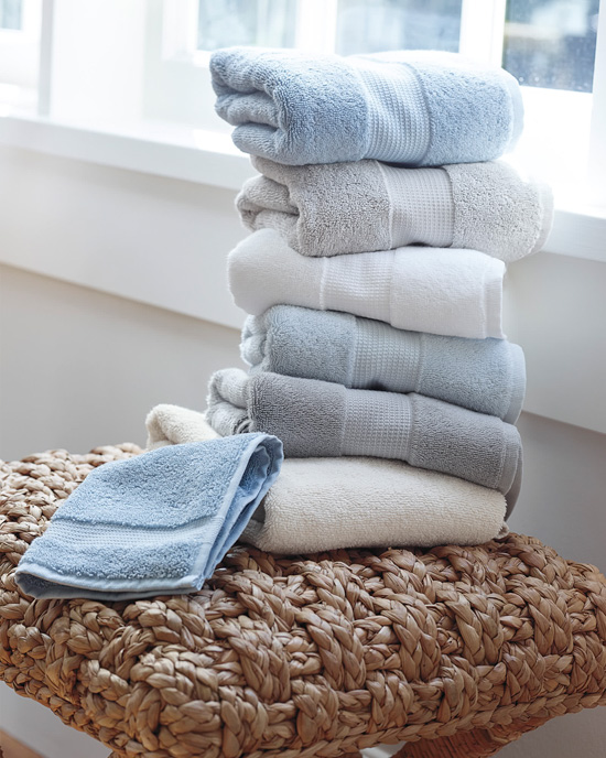 Stack of neatly folded towels in shades of blue and white. 