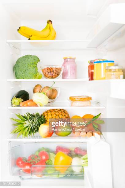 Fridge shelves filled with fruits and vegetables.