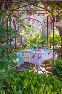 A simple gathering in the iron pergola feels extra special thanks to vintage styling and the lush layers of plantings that Jeri created to surround the space.