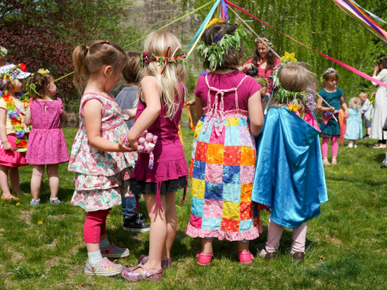 Children wearing flower crowns near the May Pole.