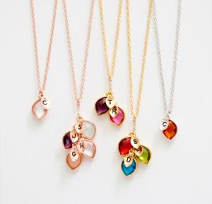 Sample necklaces with golf chains and gems and initials attached to them.