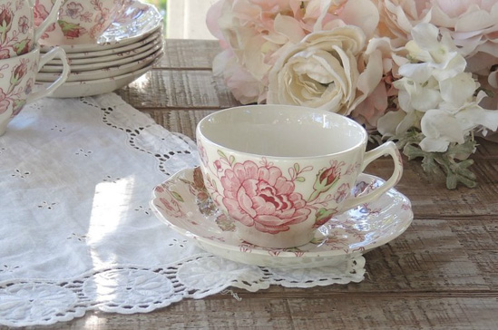 Vintage tea cup laying on a lace doily.