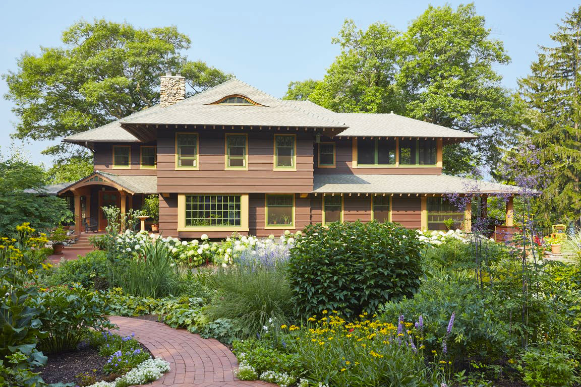 A Craftsman-style home with a natural, meadow-like garden growing in front.