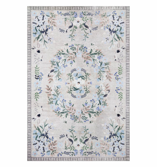 Light colored grey and blue rug with intricate floral design.