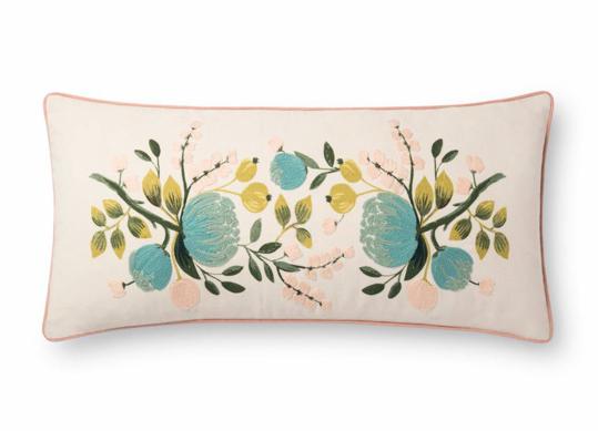 cream colored lumbar pillow with light blue and green floral design.