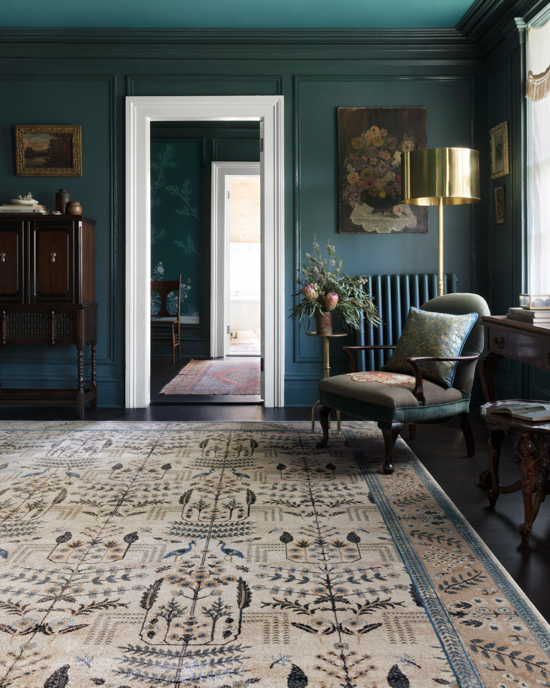 Sitting room with deep blue gem tones displaying new Rifle Paper Co. and Loloi rugs and pillows.