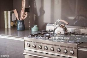 Tea kettle on the stove in a kitchen.