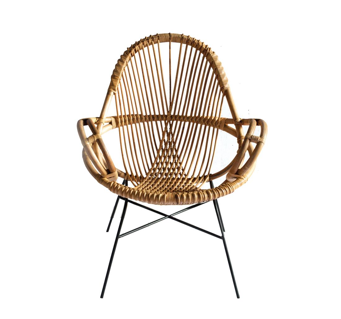 Intricate rattan chair with black metal legs. 