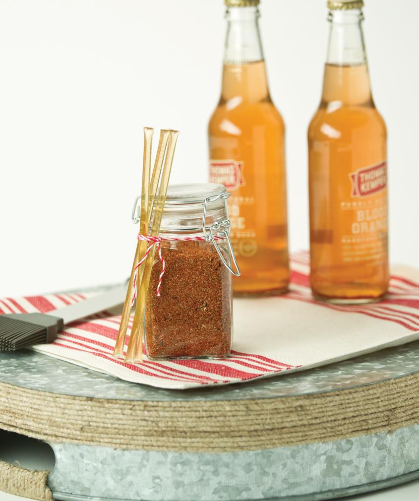 Custom rub seasoning in a jar displayed in front of two beers all ready for a summer barbecue. 