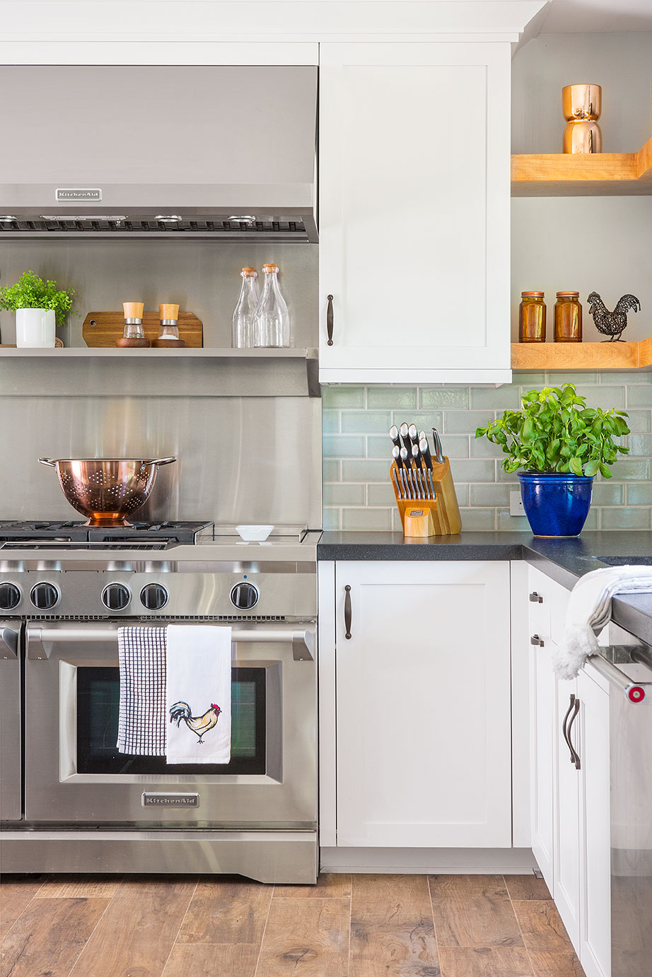 modern kitchen with white cabinets and restaurant style stainless steel range. 