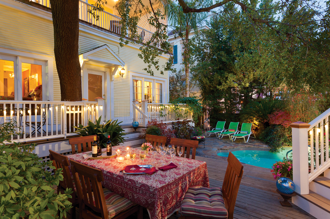 Twilight setting on a back deck with a private spa and dinner table. 