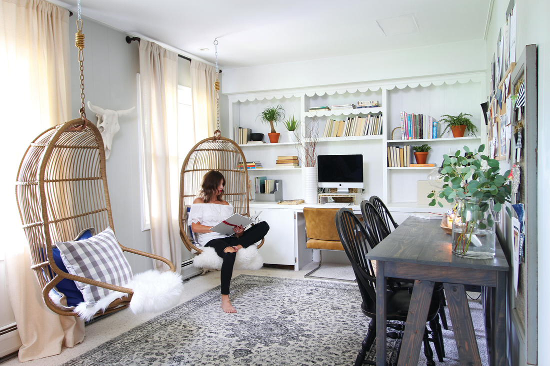 Two hanging rattan chairs and an office wall of custom builtins. 