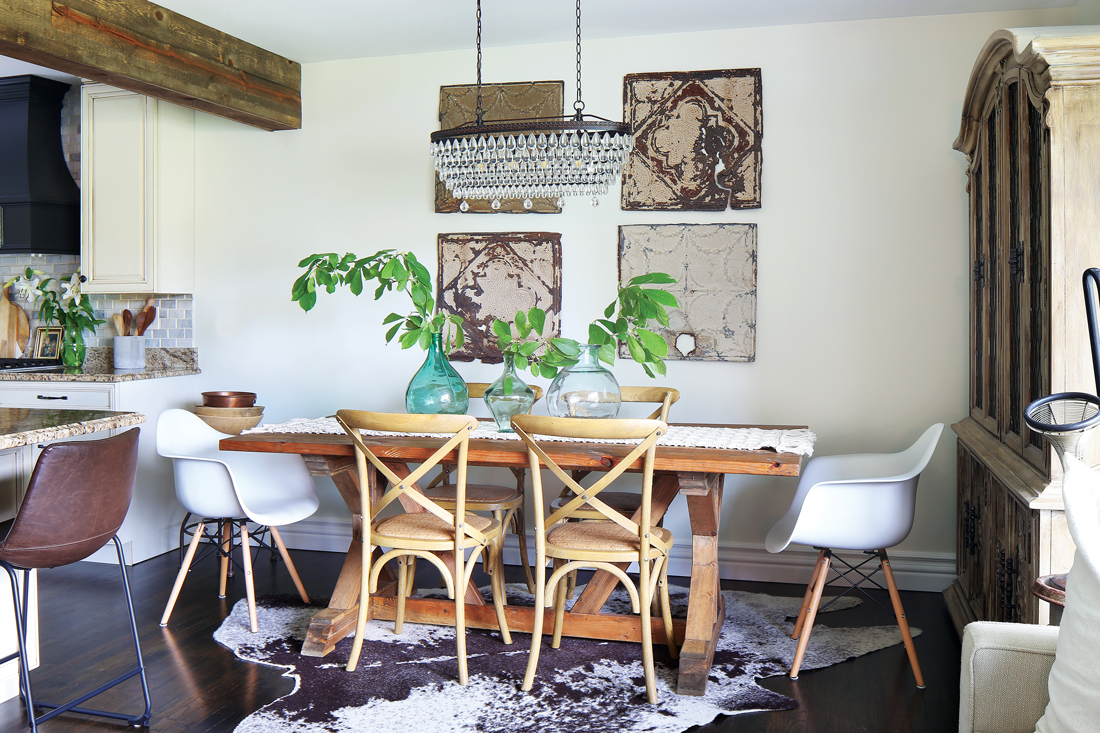 Flea market find and vintage odds and ends give a funky fun look to this dining area off the kitchen. Wooden trestle table and modern bucket chairs with a crystal chandelier. 