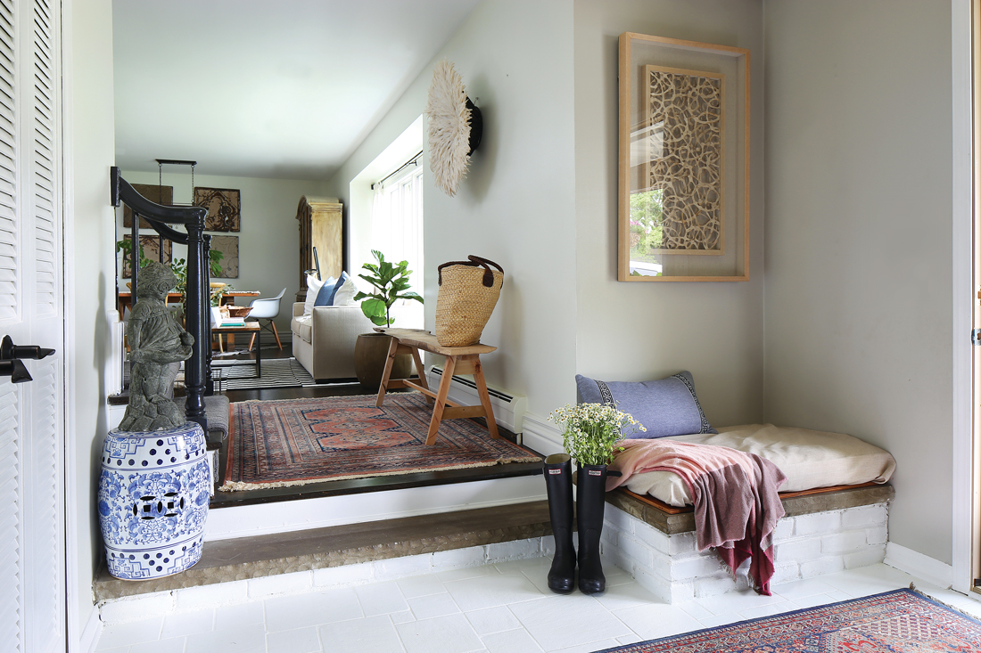 Looking into the living room from the entryway, beckoning you in with Persian rugs and bright window light. 