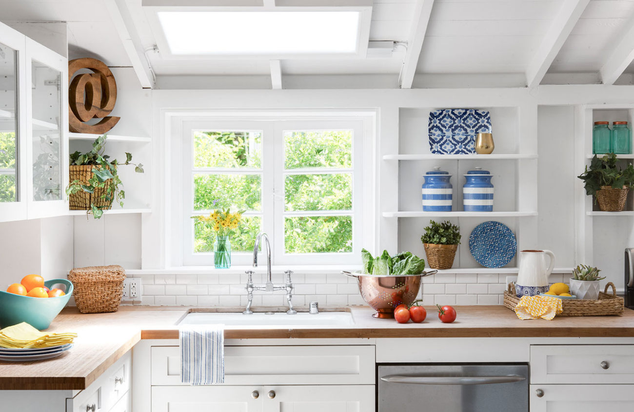 bright white kitchen with blue accents and wooden countertops.